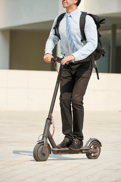 Businessman riding on electric scooter