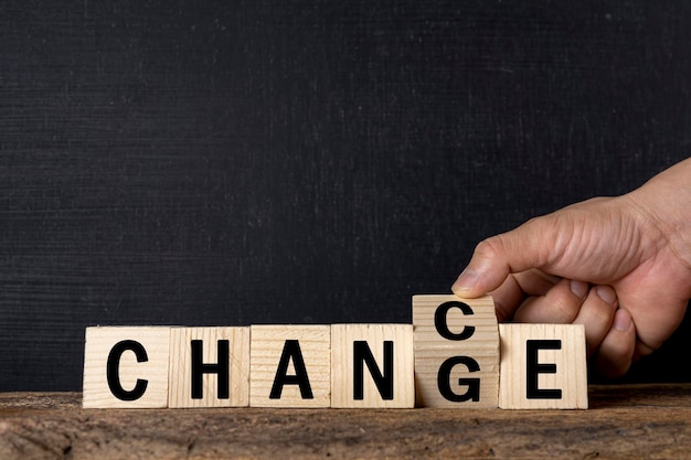 Photo a businessman's hand flips over a wooden cube whose word has been changed to opportunity