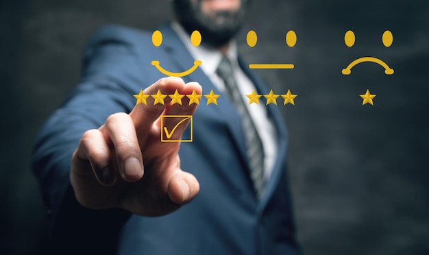 Businessman's hand pressing with a checkmark on checkbox on smiley face emoticon on virtual touch screen on dark background Customer service evaluation client experience satisfaction survey