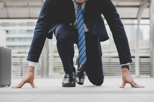 Businessman set in start running position prepare to fight in business race.