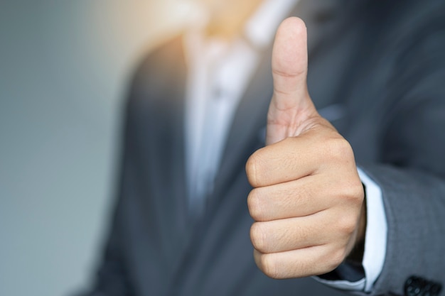 Businessman showing signal with thumb raised up