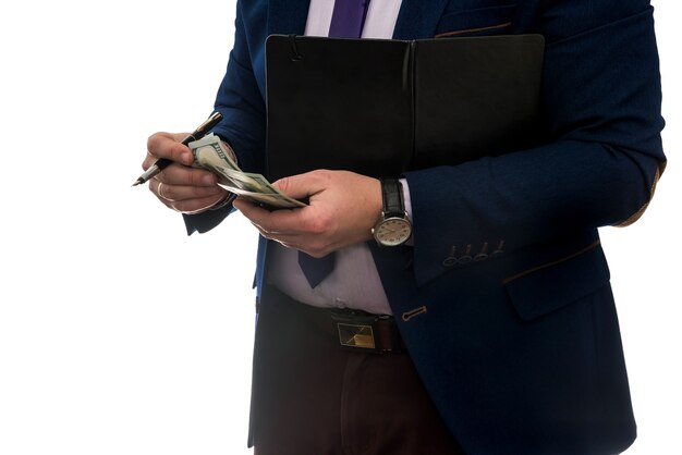 Businessman signs purchase or lease agreement, holding dollars on isolated white wall