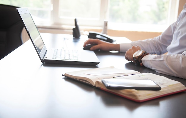 Businessman sitting in modern office and working on his laptop