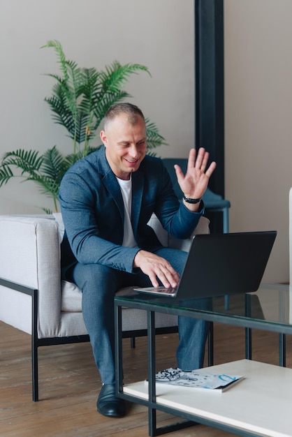 Businessman sitting in an office working with a laptop computer. Business man portrait.