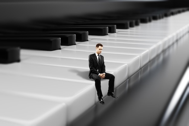 Businessman sitting on piano keys