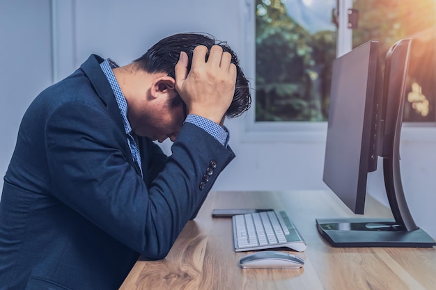 Businessman sitting stressed out in front of a computer