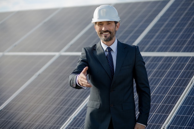 Businessman at solar energy etation holding hand.