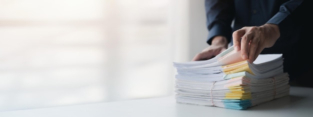 Businessman sorting stacks of department meeting papers document management in corporate office Office document management and storage concept