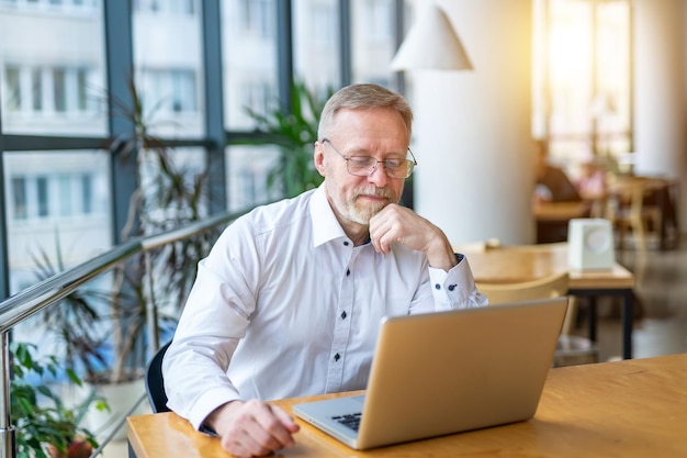 Businessman speaking with colleagues over the laptop Distant work Video conference from home Isolation because of pandemic