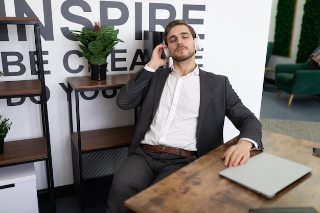 Businessman speaks on a mobile phone imposingly sitting in a chair