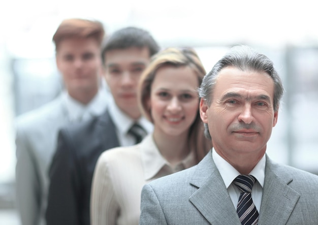 Photo businessman standing in front of his business team on blurred office background