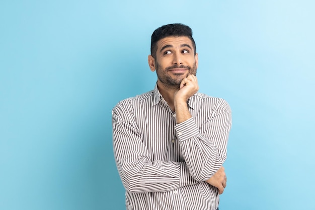 Businessman standing and looking away with thoughtful expression imagining something pleasant