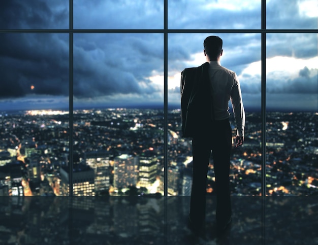 Businessman standing in night offic