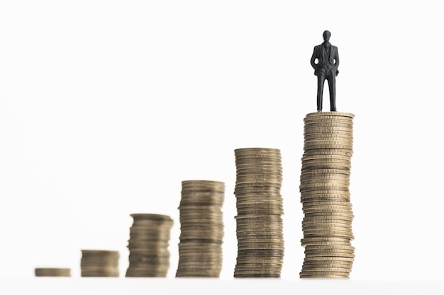 Businessman standing on stack of growing coins