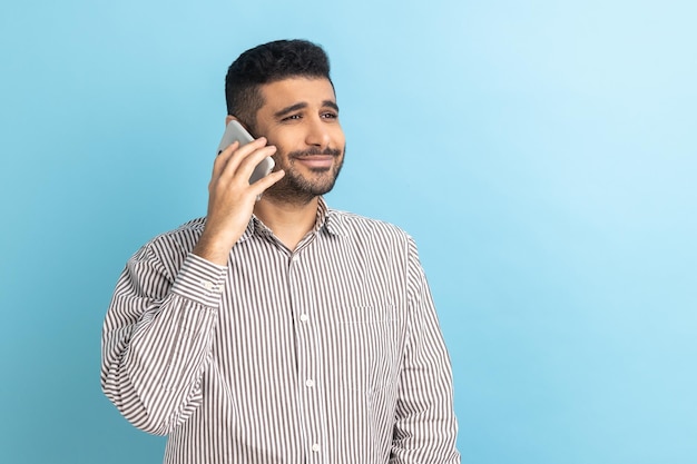 Businessman standing talking smartphone making call and having pleasant conversation with friend