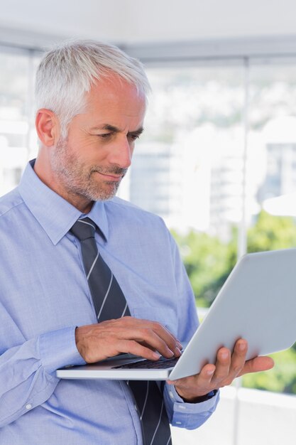 Businessman standing and using laptop