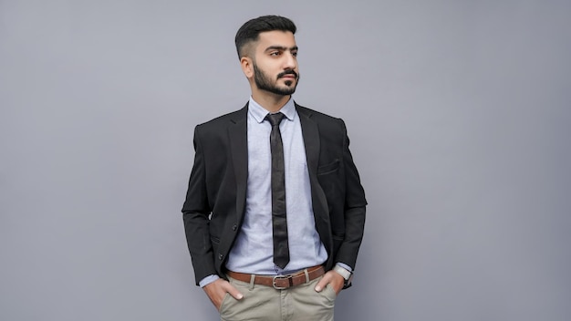 businessman standing with hands in pocket looking right in black suit indian pakistani model