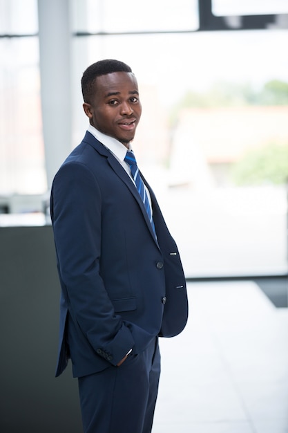 Businessman standing with hands in pocket in office