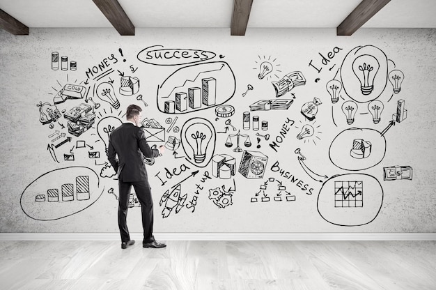 Businessman and startup icons on concrete wall