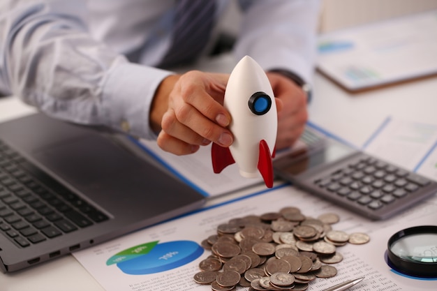 Businessman in suit hold white rockrt in hand