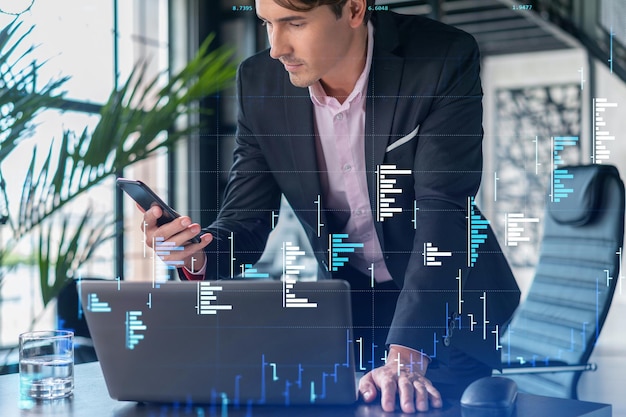 Businessman in suit using smart phone to optimize trading strategy at corporate finance fund Forex chart hologram over modern panoramic office background