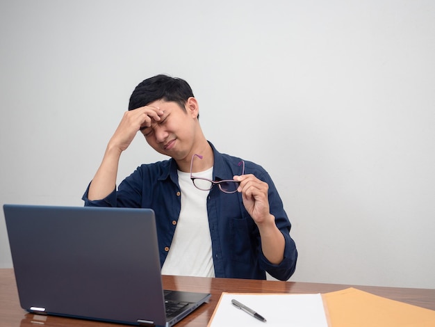 Businessman take off his glasses feels tried about work hard