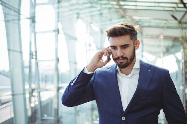 Businessman talking on mobile phone at railway station