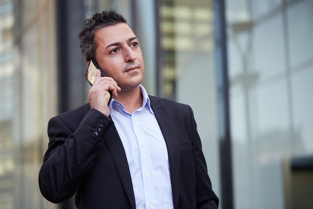 Businessman talking to mobile in urban environment