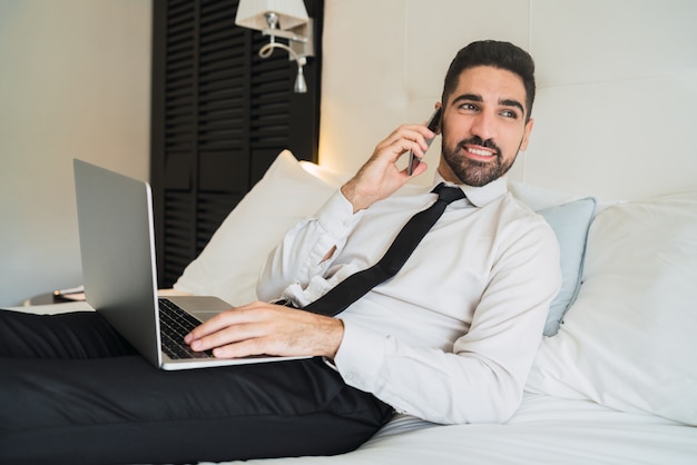 Businessman talking on phone at hotel room.