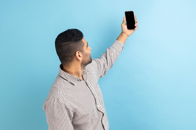 Businessman talking video call taking selfie on mobile phone holding smartphone up with mockup