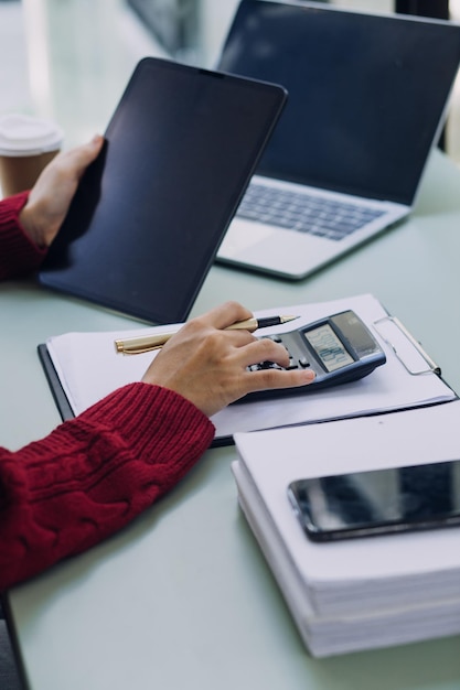 Businessman and team analyzing financial statement Finance task with smart phone and laptop and tablet Wealth management concept