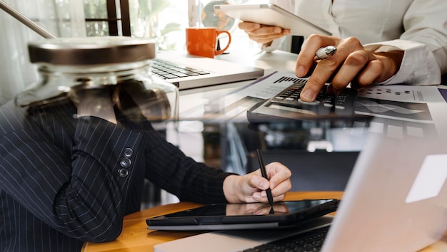 Businessman and team analyzing financial statement Finance task with smart phone and laptop and tablet Wealth management concept