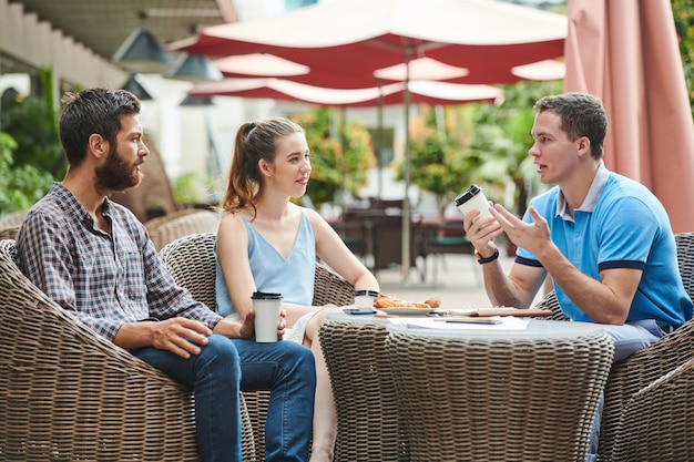 Businessman telling ideas to coworker in cafe