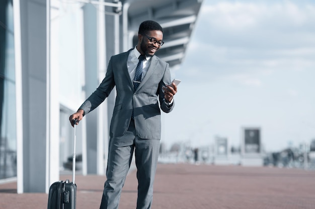 Businessman Texting On Phone Arriving at Airport