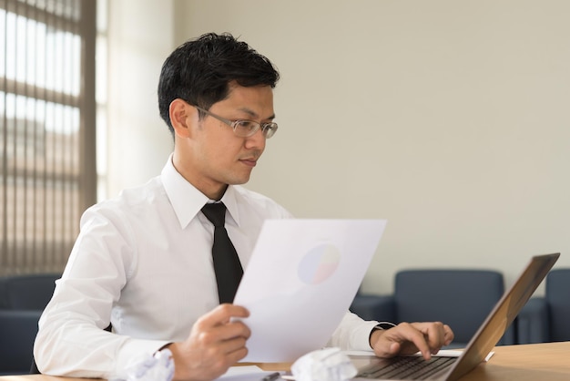 Businessman thinking his business matters with much stress at the OfficeHis company's stock fallbright room in the sunny day