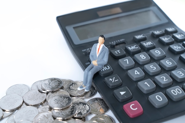  Businessman thinking or making decision with calculator and coins stack.