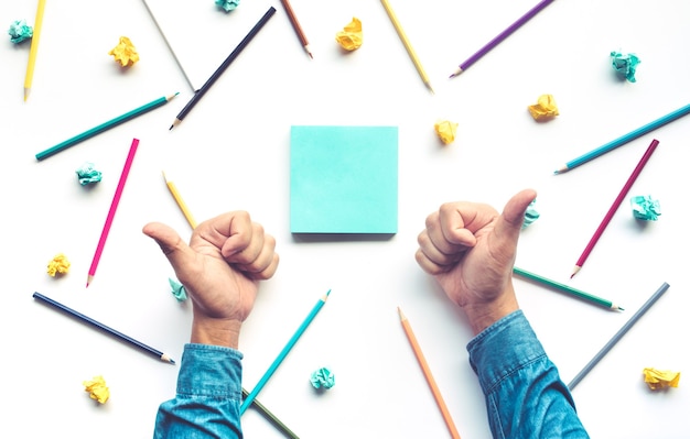 Businessman thumb up hand for celebrate idea with pencil and notepaper on white table.Business creativity and education concepts