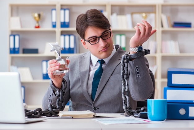 Businessman tied with chains to his work