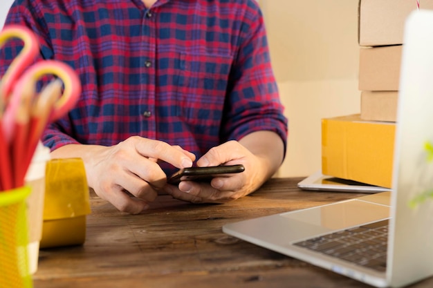 Photo businessman use smartphone thinking with pile of parcel on work desk