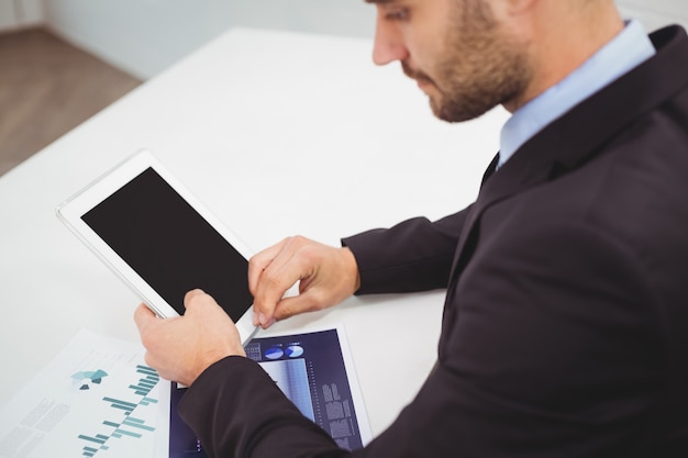 Businessman using digital tablet at desk in office