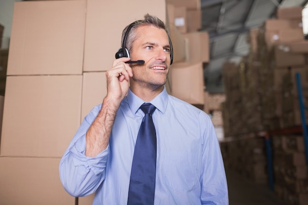 Businessman using headset in warehouse