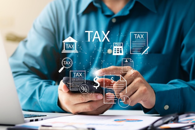 Photo businessman using his laptop computer and smartphone to fill out online personal income tax