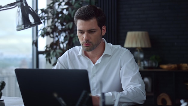 Businessman using laptop computer in officeEmployee typing on computer keyboard