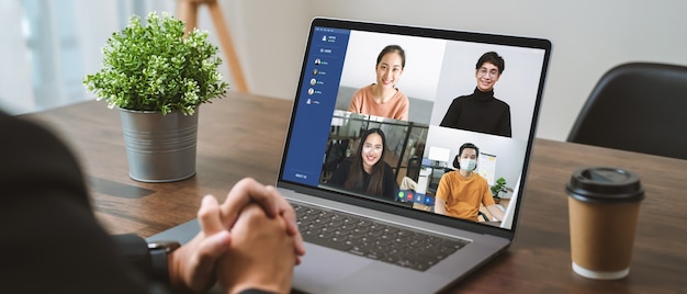 Businessman using laptop on table with making video call meeting to team online and present work projects. Concept working from home.