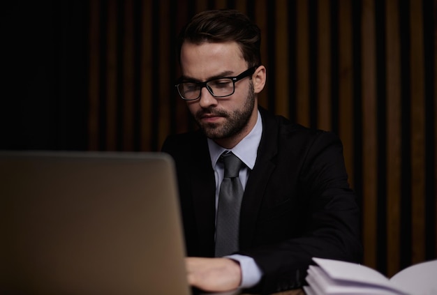 Businessman using a laptop while working late in his office