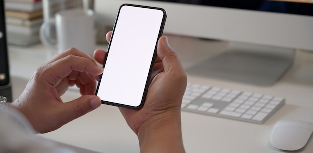 Businessman using mobile phone blank screen display in office