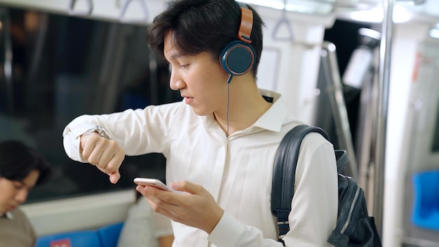 Businessman using mobile phone on public train . Urban city lifestyle commuting concept .