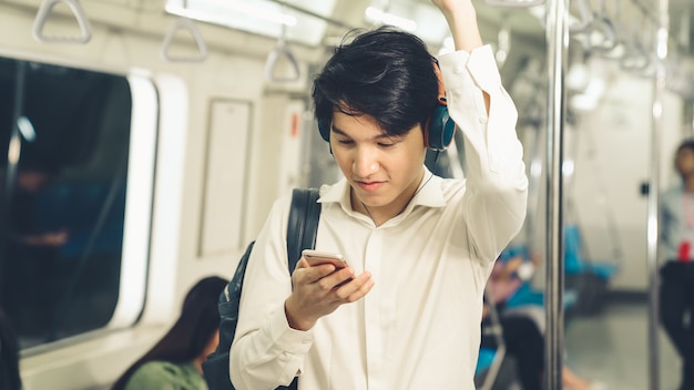 Businessman using mobile phone on public train