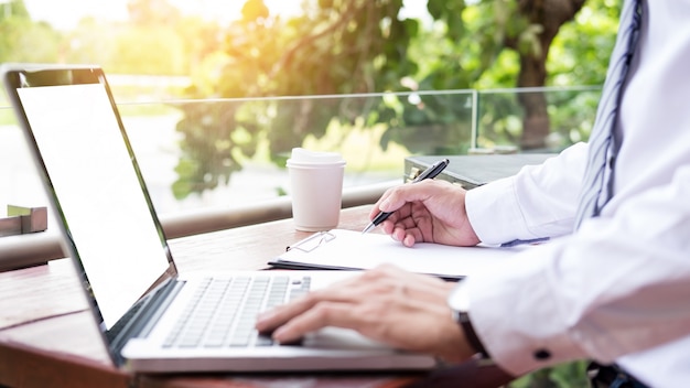 businessman using modern laptop for working at personal space outdoor,  wireless connection internet on his notebook computer