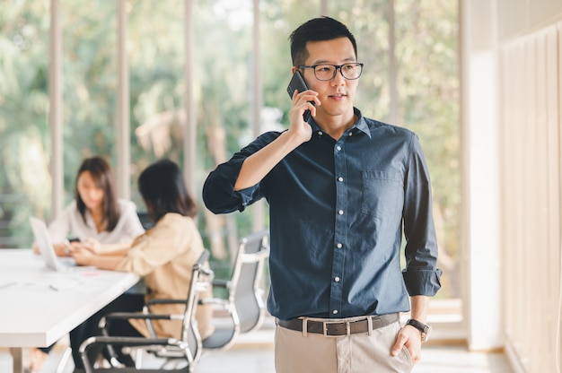 Businessman using smartphone to discuss business plan in meeting room